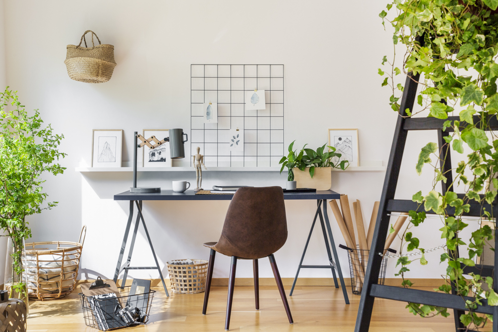 Brown chair at desk in white boho home office interior with plan